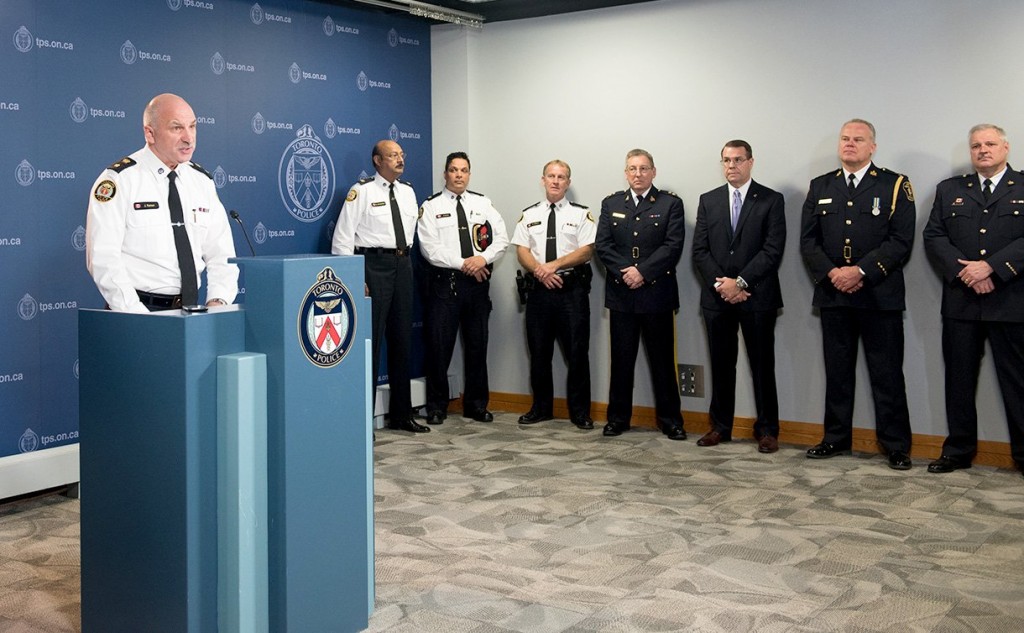 Ramer addressing reporters while other law enforcement officers look on at the conference in Toronto.