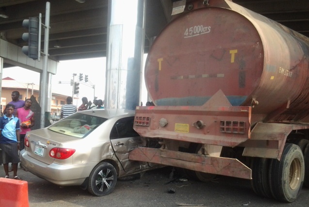 Crushed car and sympathizers at the scene of the auto crash.