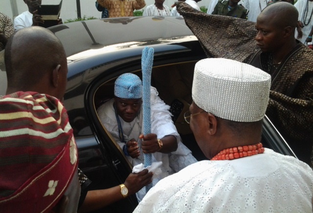 Ooni alighting from his car as Osile waits to welcome him.