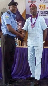 *Adejobi in handshake with Amos after receiving award at the event.