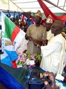 *Lawal (left) receiving APC flag from Chief Tajudeen Lemboye, APC Deputy State Chairman.