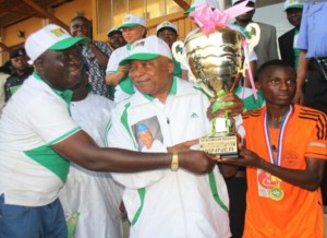 *Sir Kessington Adebutu presenting trophy during Under-18 soccer contest.