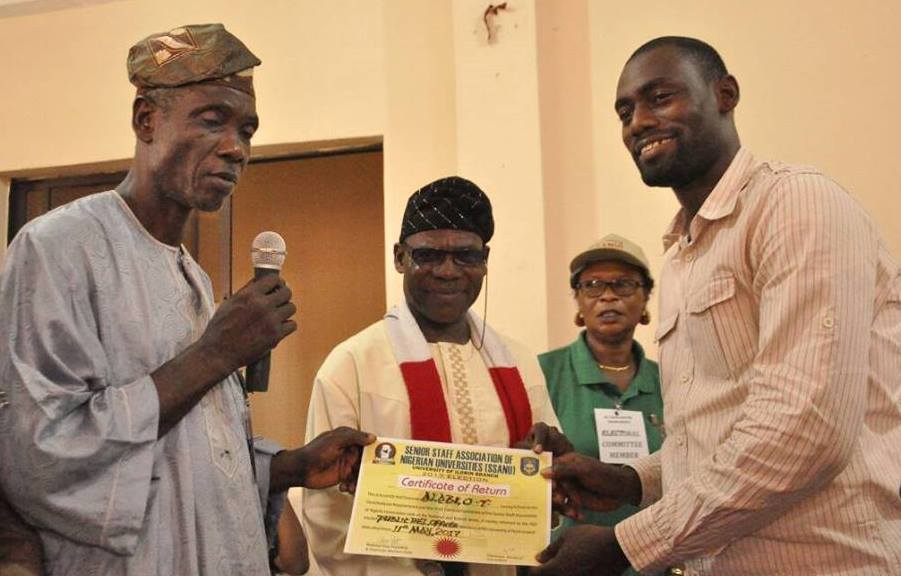 Olafare (left) presenting certificate of return to Alabi at the swearing in.