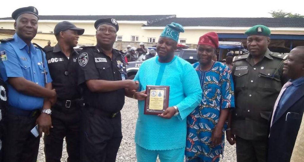 Iliyasu receiving award from Olaniyan while others watch.