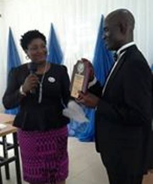 Afuape receiving award from the representative of the association.